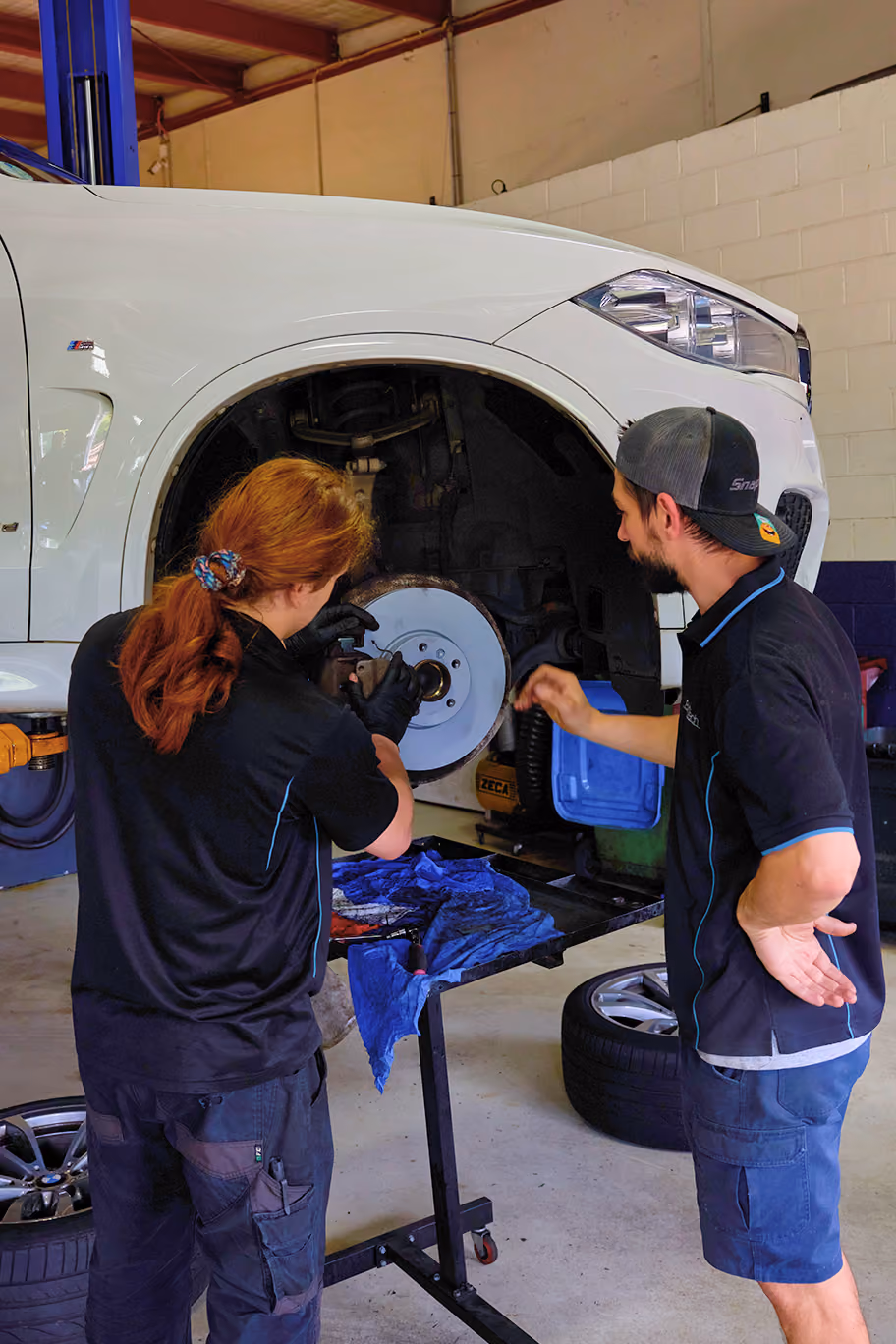 Range Rover raised on a workshop hoist during brake service.