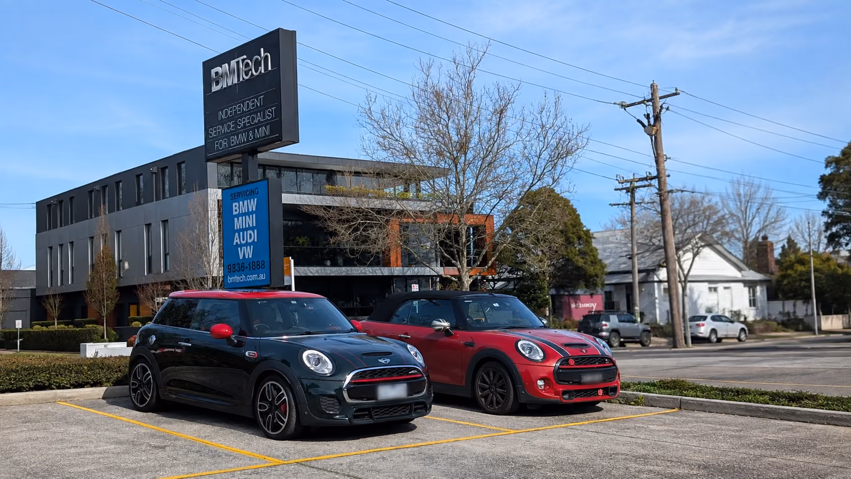 Two MINI vehicles parked outside the BMTech independent BMW and MINI service centre.