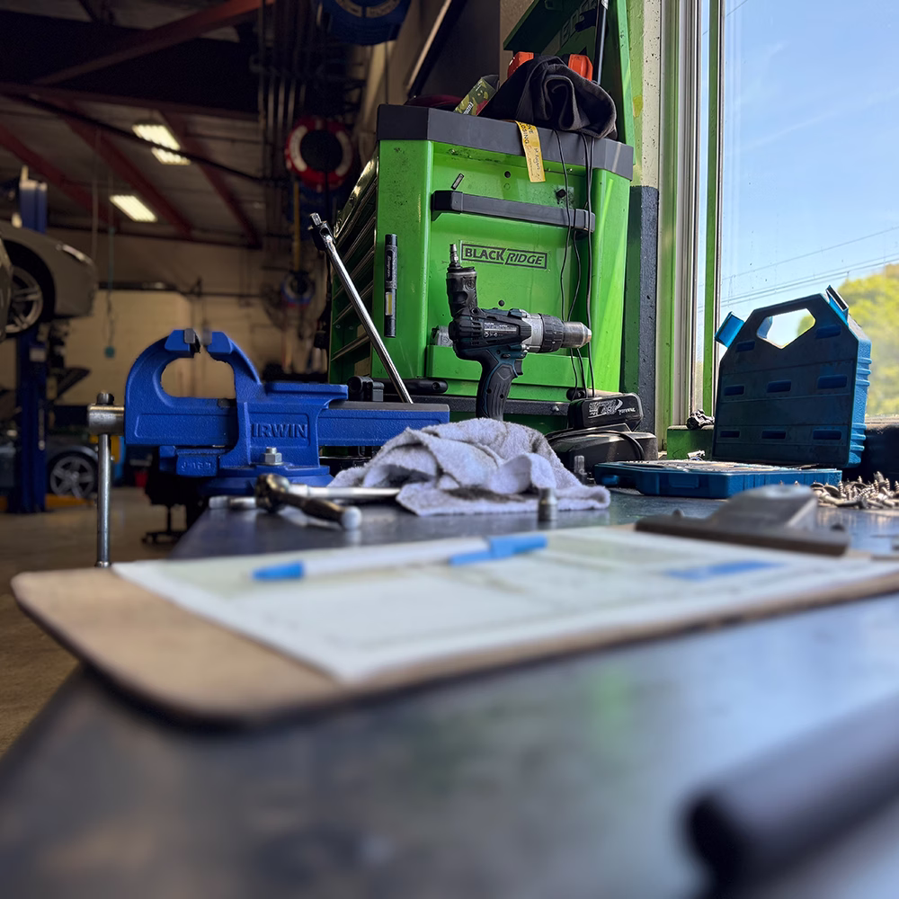 BMT Workshop workbench with tools and a car on a lift