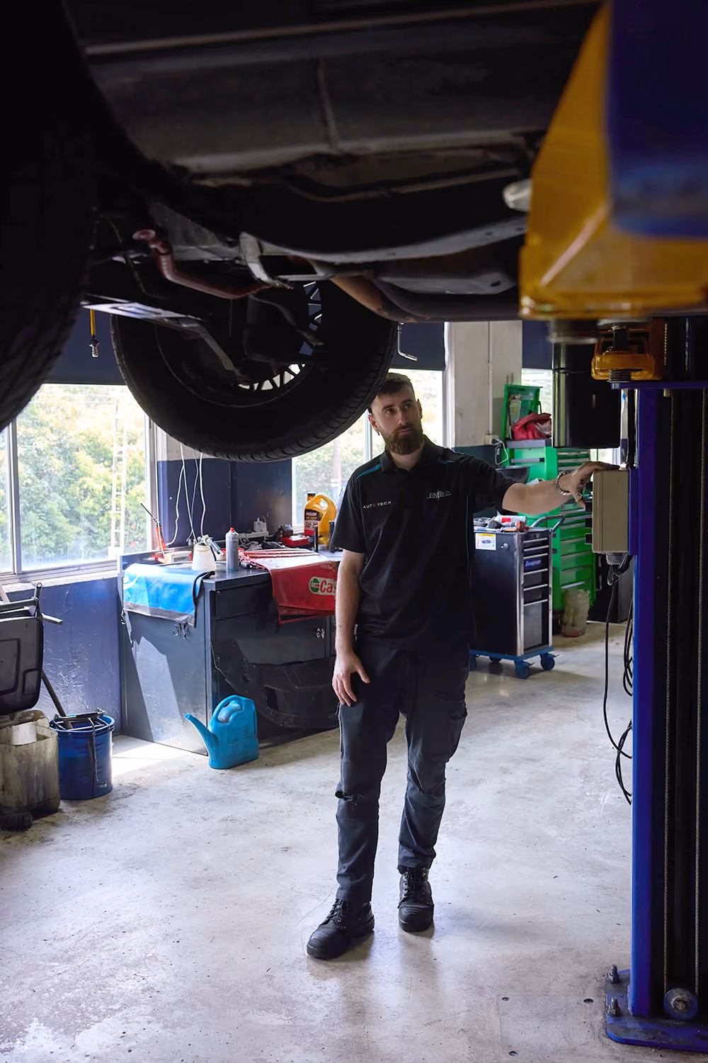 BMT Technician inspecting a vehicle raised on a lift in the BMT Workshop