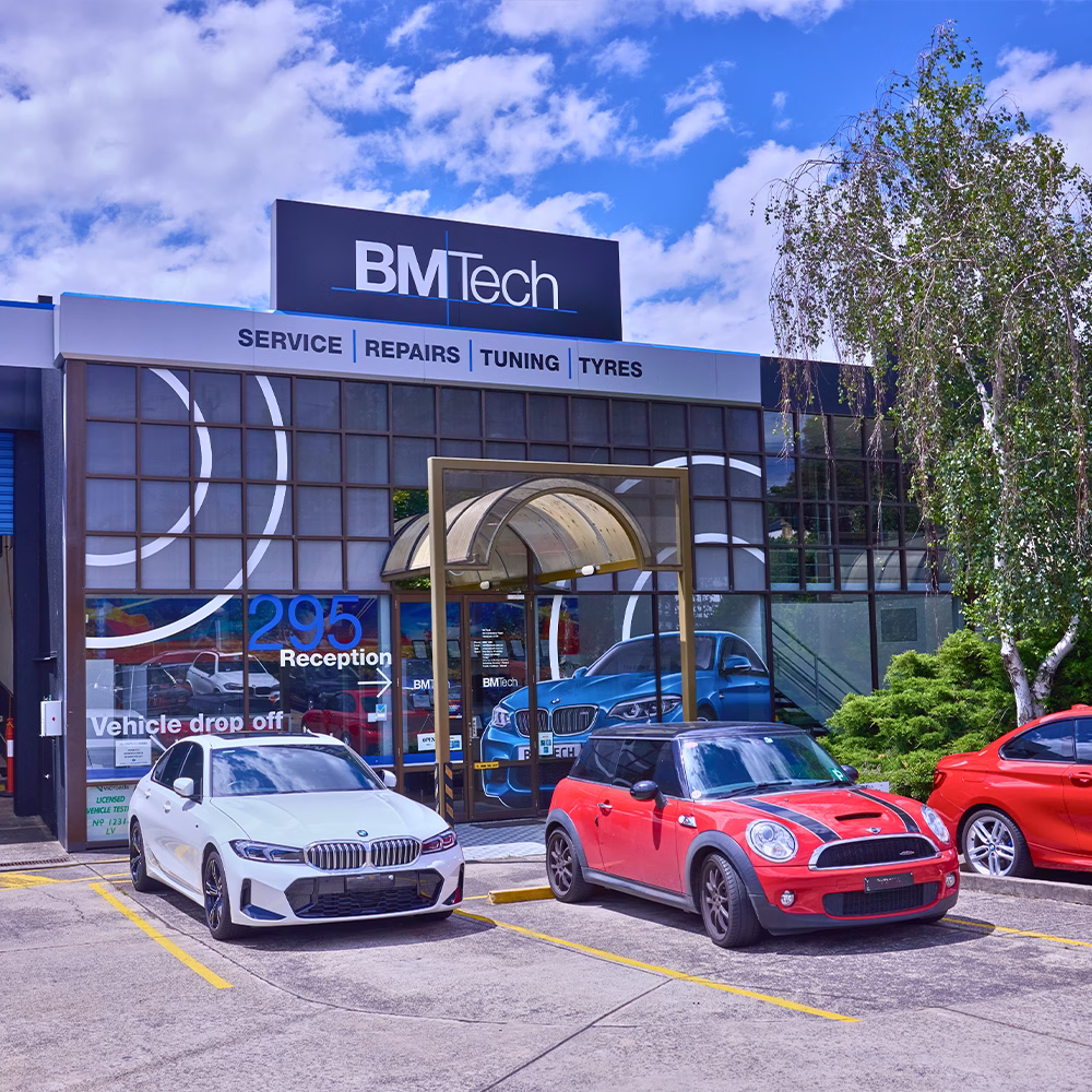 Exterior of the BM Tech workshop in Melbourne with BMW and MINI vehicles parked out front.