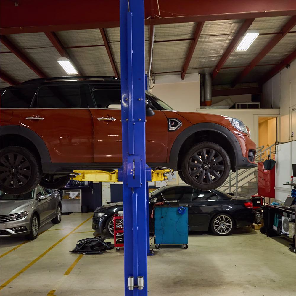 MINI Countryman raised on a vehicle hoist inside an automotive workshop.