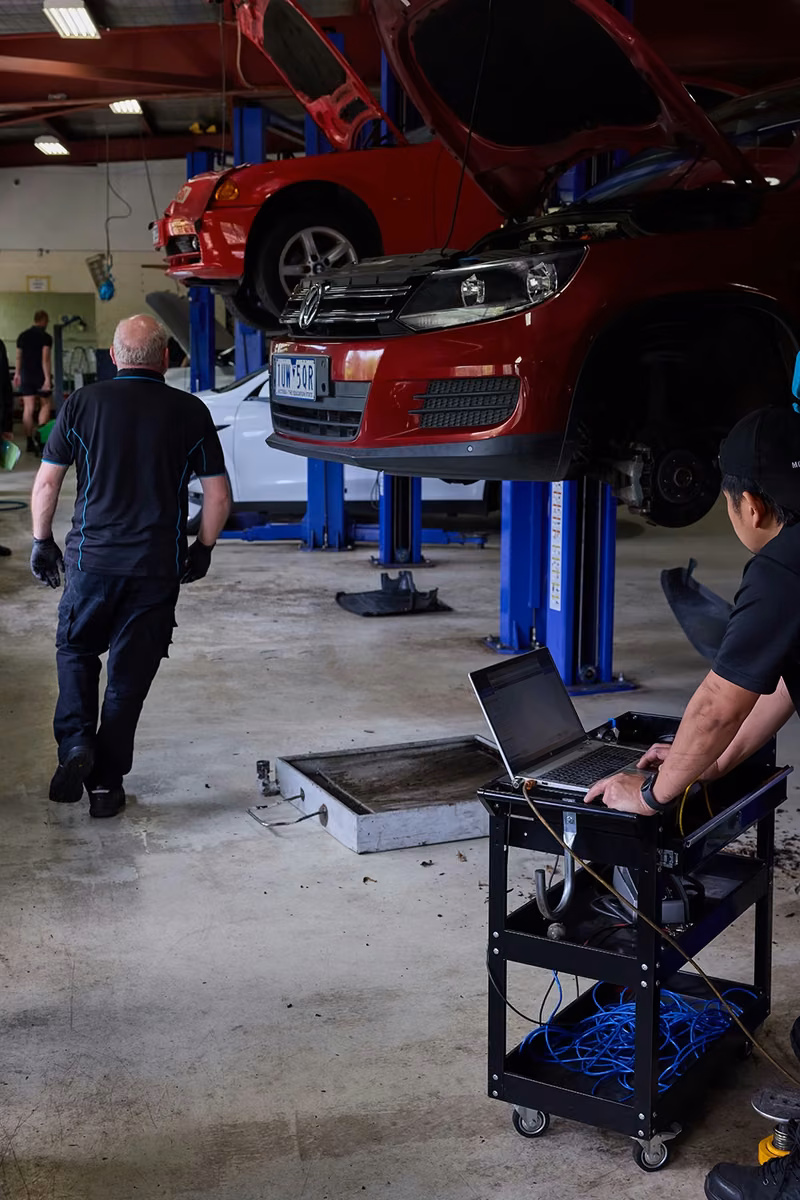 BMT Technician running laptop diagnostics on a car in the BMT Workshop