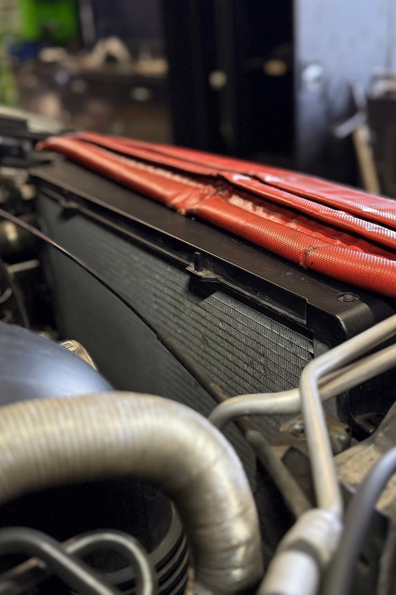Close-up of a car radiator in the engine bay at the BMT Workshop