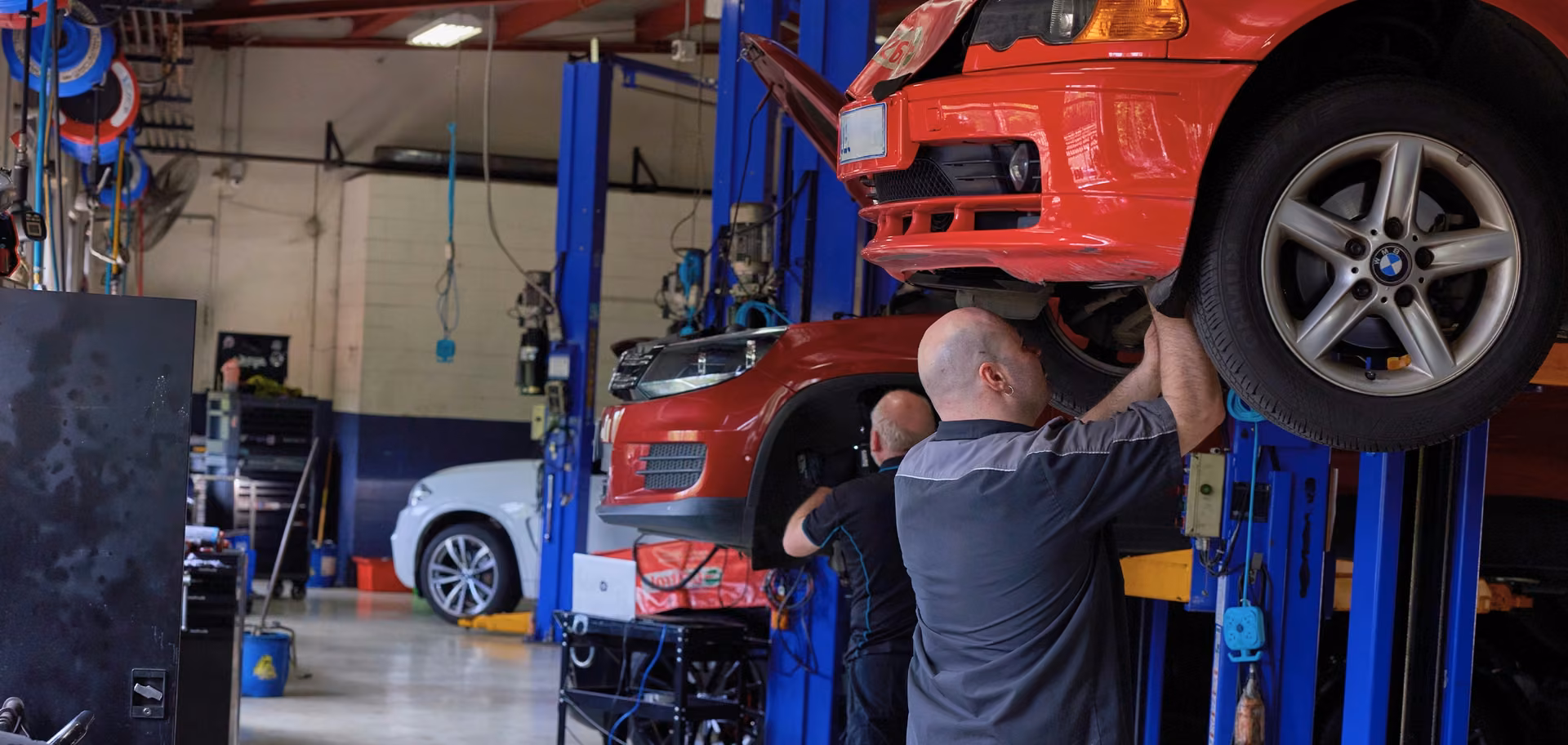 European vehicles raised on hoists inside the workshop.