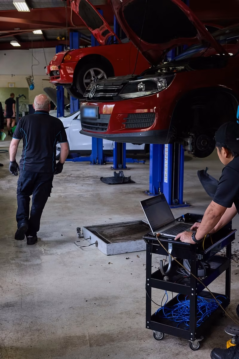 BMT Technician running laptop diagnostics on a car in the BMT Workshop