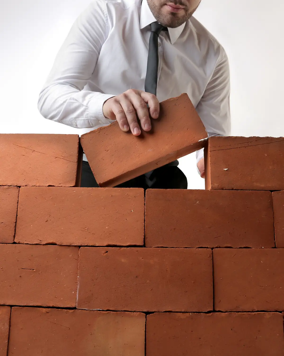 Professionnel du bâtiment posant une brique sur un mur en construction