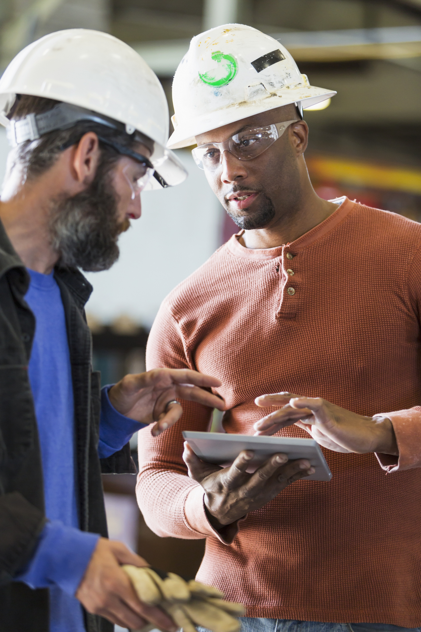 Two workers in conversation in an industrial setting