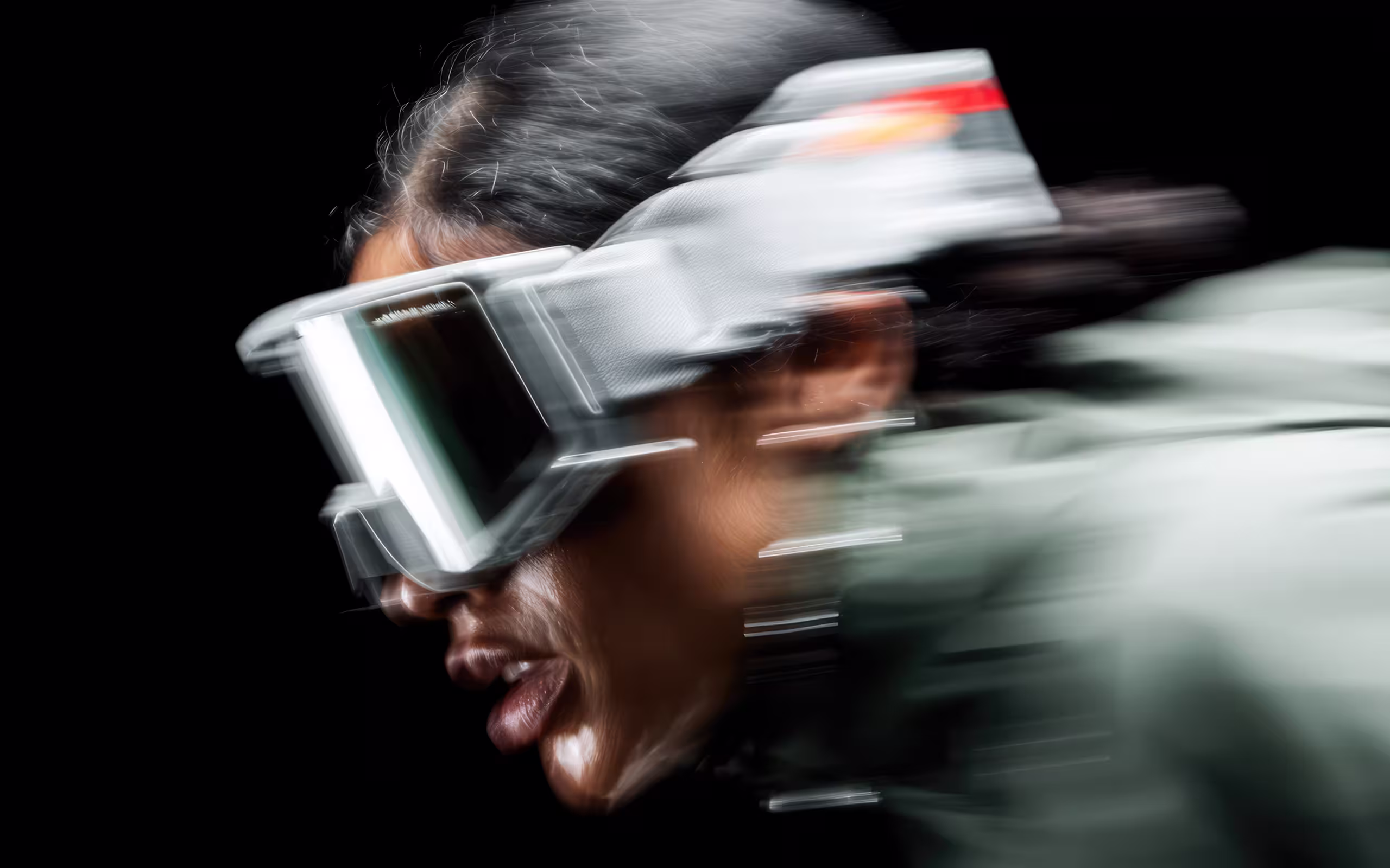 Blurred close-up of a person wearing large protective goggles and a white jacket against a black background.