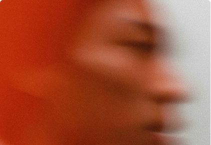 Blurred profile of a person with warm orange and beige tones in motion.