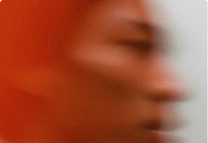 Blurred profile of a person with warm orange and beige tones in motion.