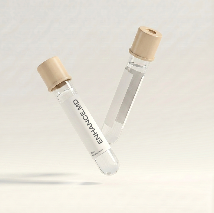 Two clear test tubes with beige caps, one labeled ENHANCE.MD, against a light background.