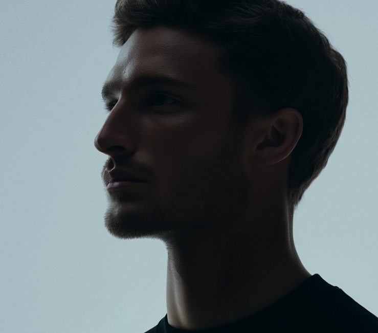 Profile portrait of a young man with short hair and light beard against a plain background.