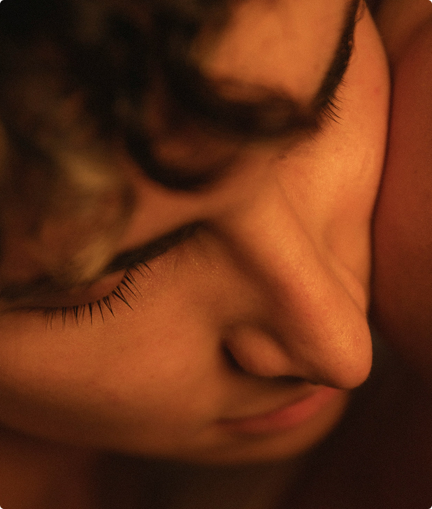 Close-up of a person's peaceful face with closed eyes and curled eyelashes.