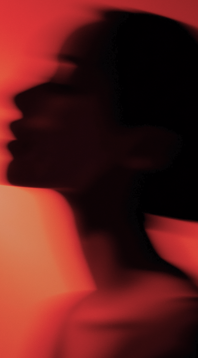 Blurred silhouette of a person's side profile against a gradient red background.