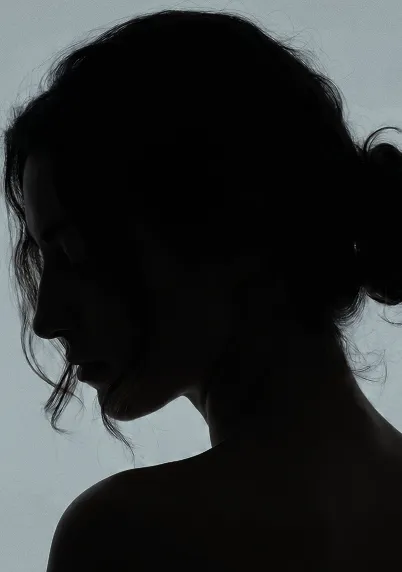 Silhouette of a woman in profile against a light background with hair tied back.