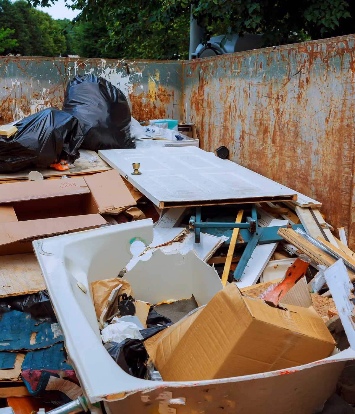 Container mit Holz, Kartons und Sperrmüll nach einer Entrümpelung