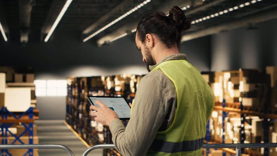 Warehouse worker using a tablet to manage inventory in a warehouse