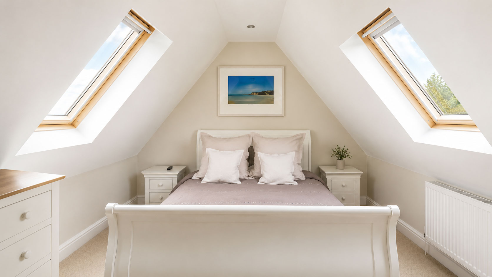 Loft conversion bedroom with two roof windows and a white sleigh bed