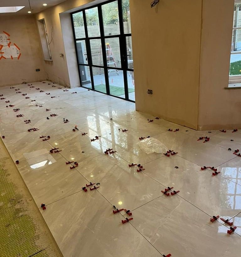 Glossy white porcelain floor running up to the black-framed garden doors