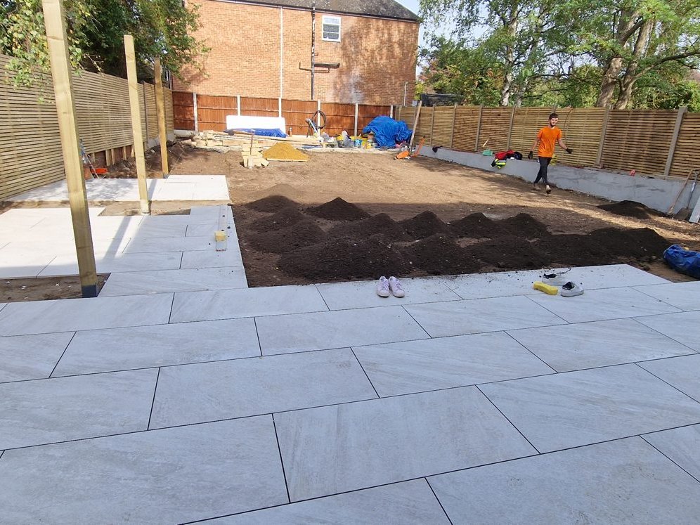 Porcelain terrace laid, with topsoil heaped ready for the lawn