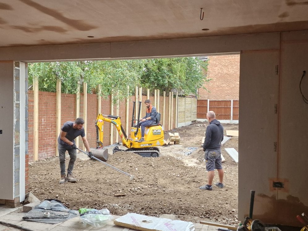 View through the new rear opening as a mini digger levels the garden