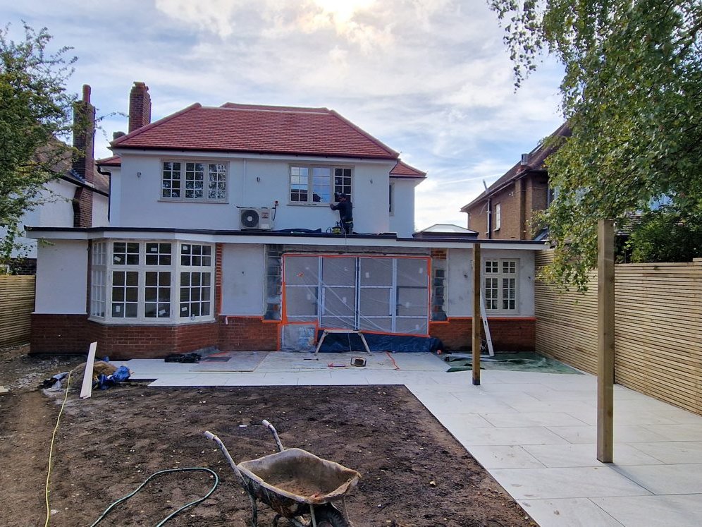 Rear of the house during rendering, with the new patio laid and the garden still bare earth