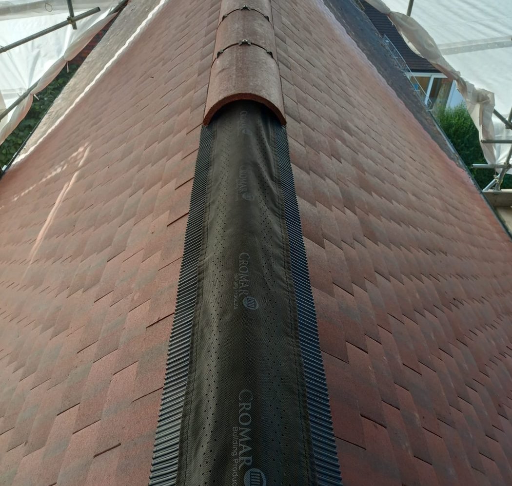 Black dry ridge roll laid along the ridge, with the first half-round ridge tile in place