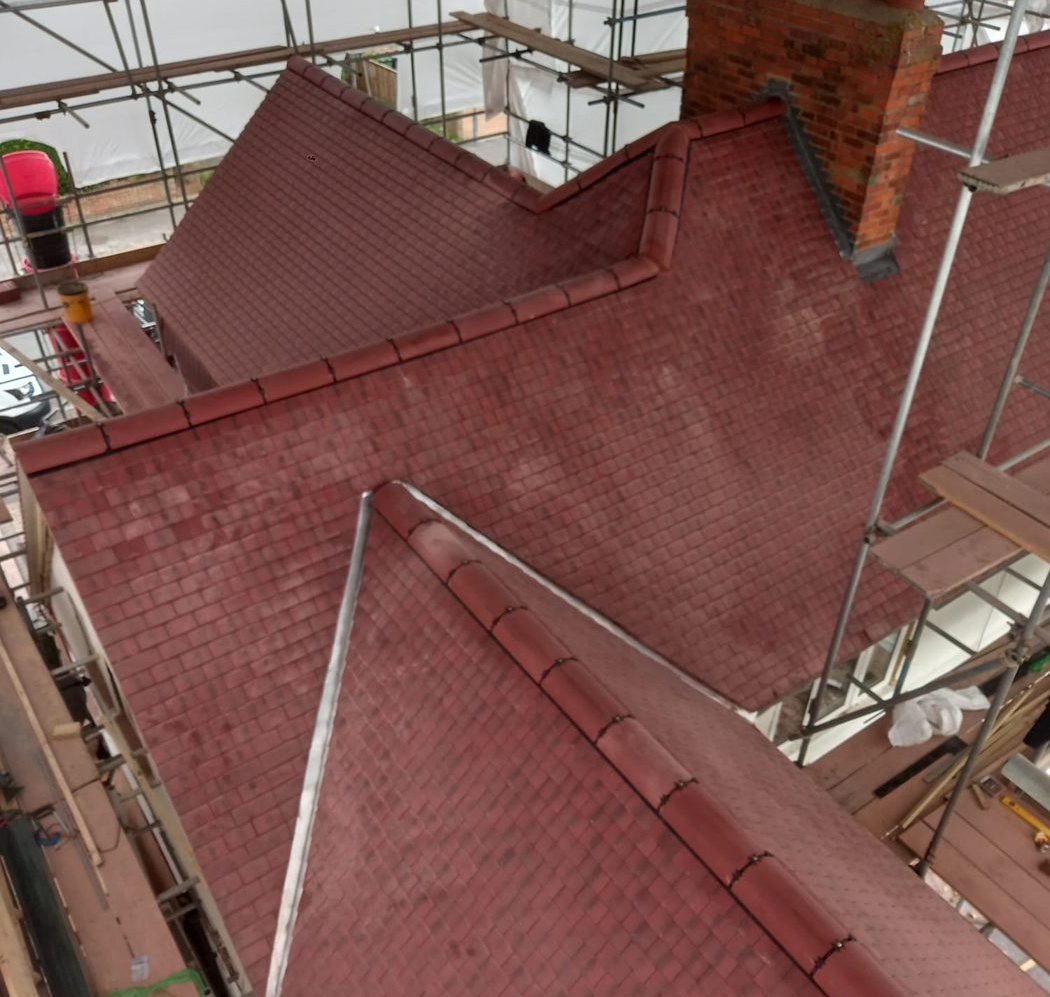 The same roof complete, with the hips, valleys and ridge tiles finished around the chimney