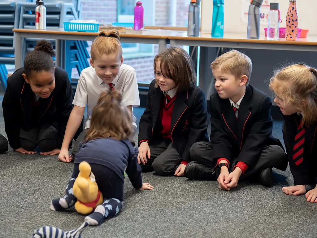 A group of children observing a baby during a Circles for Learning school session
