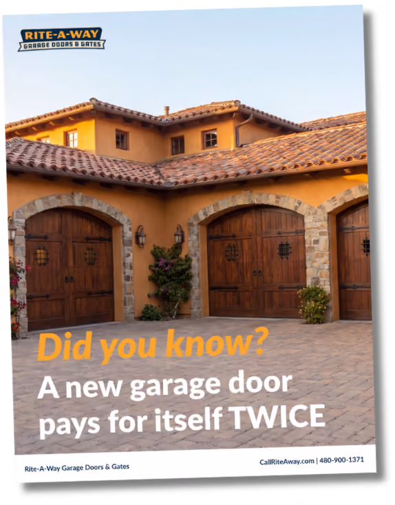 Three wooden garage doors with stone arches on a large house with a tiled roof at sunset.