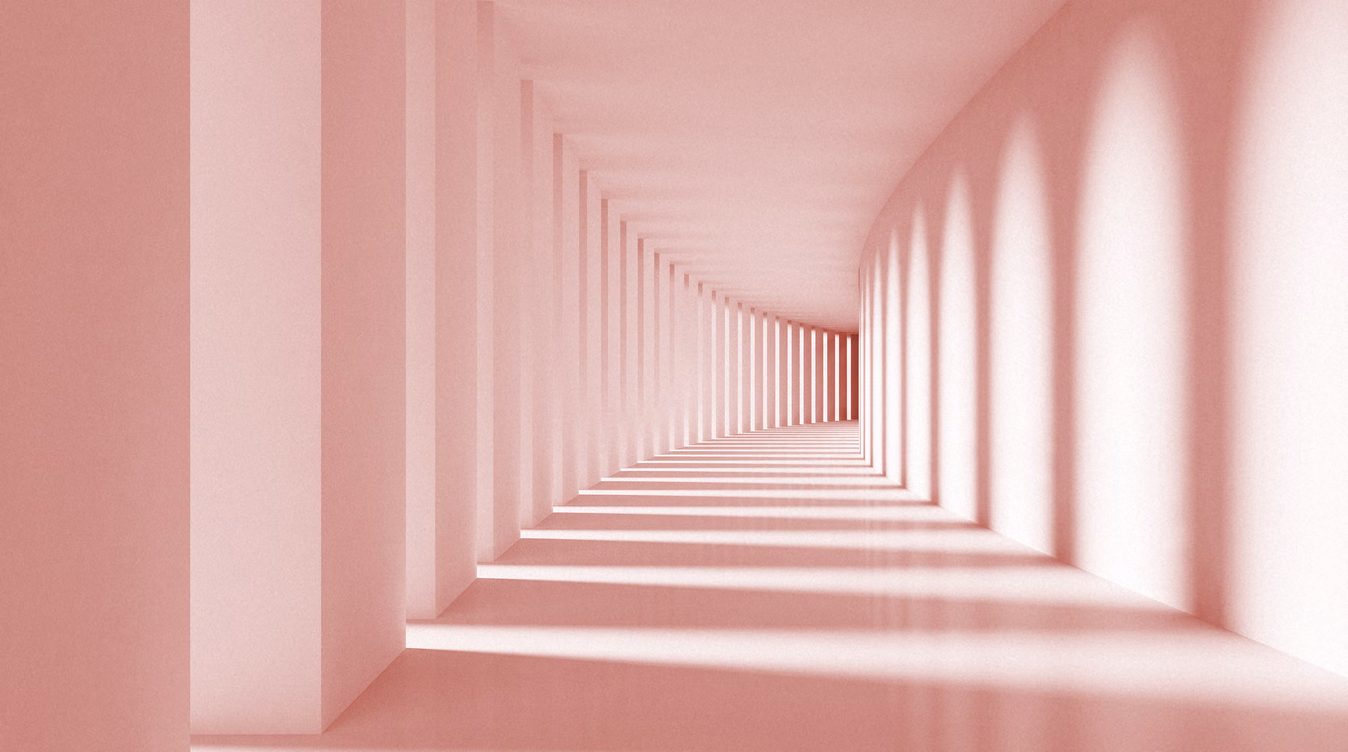 Couloir long et incurvé avec une série d'arcs créant des ombres allongées sur le sol, le tout dans une teinte rose pâle uniforme.