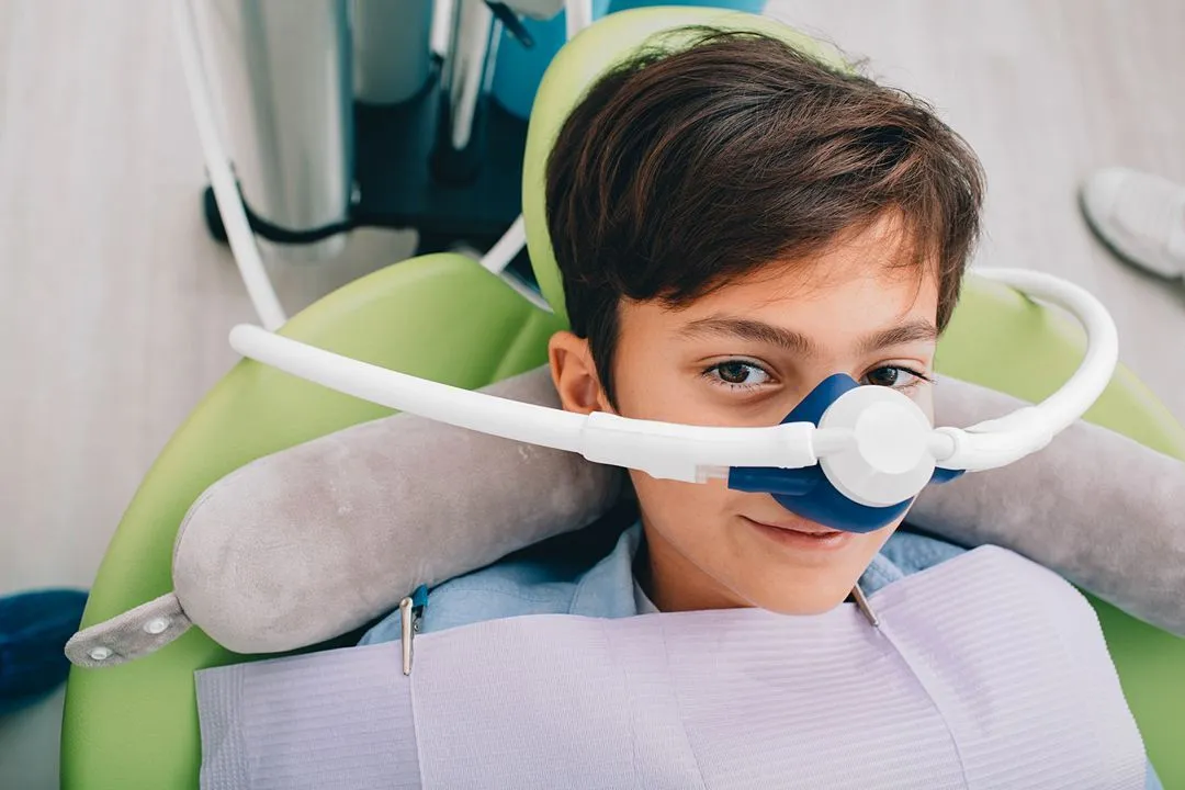 Patient wearing a nitrous oxide nasal mask during sedation dentistry