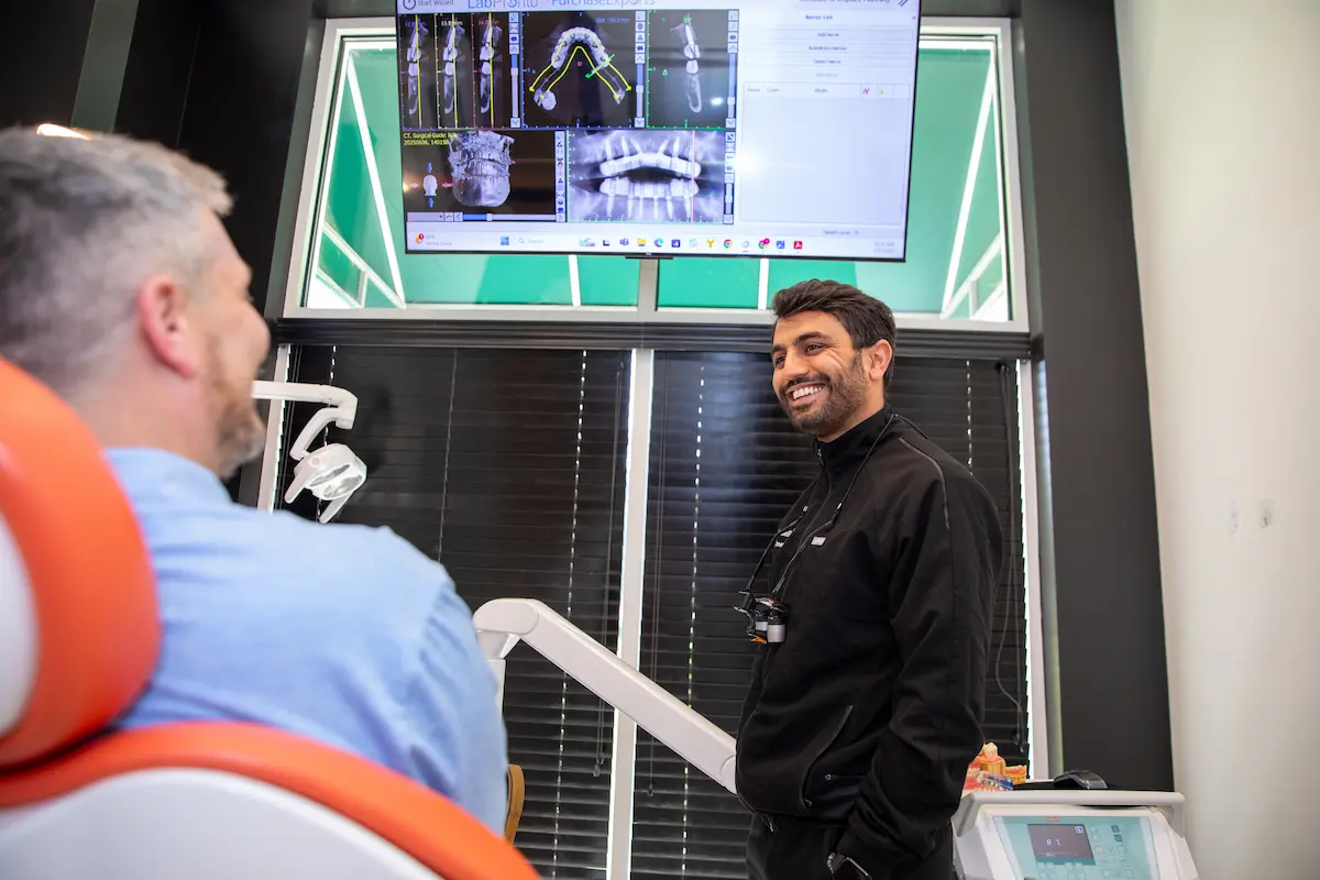 Dentist reviewing treatment images with a patient on a chairside screen