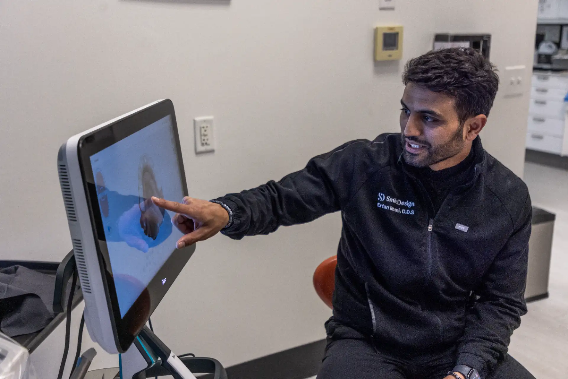 Dentist explaining a dental X-ray on a treatment room monitor