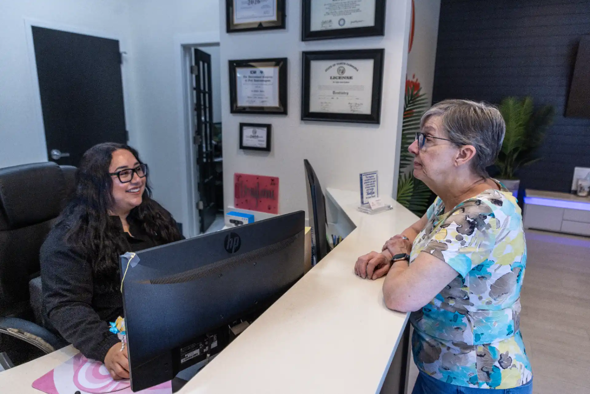 Front desk team member helping a patient at the reception computer
