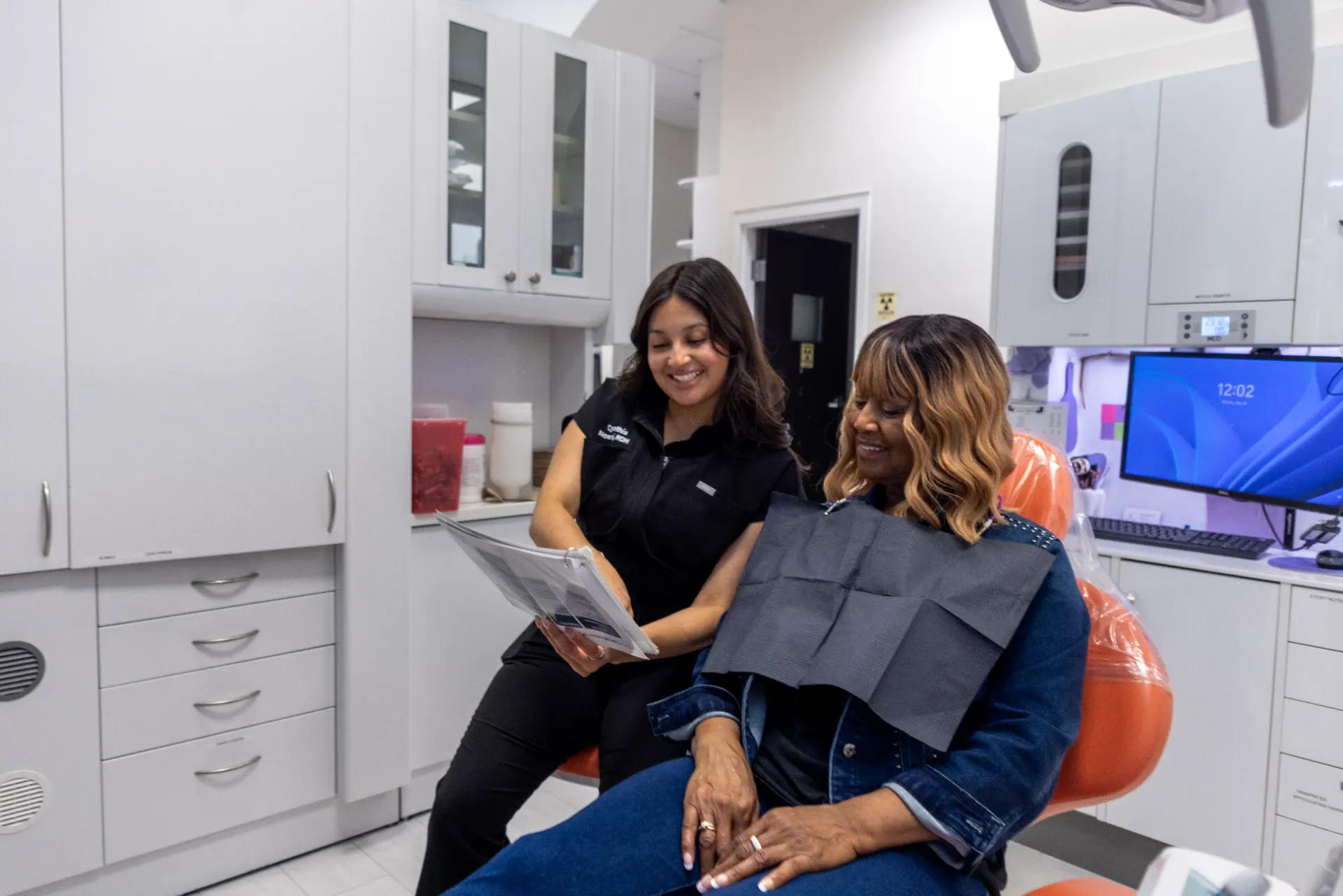 Dental team members reviewing treatment information with a patient at Smile Design Modern Dentistry in Durham, NC