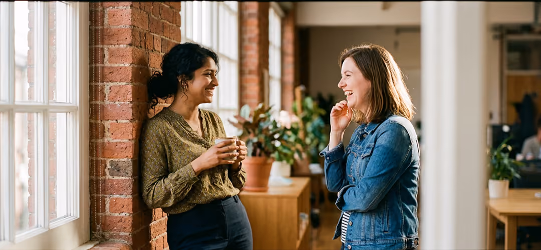 Deux femmes échangeant avec le sourire dans un espace de coworking