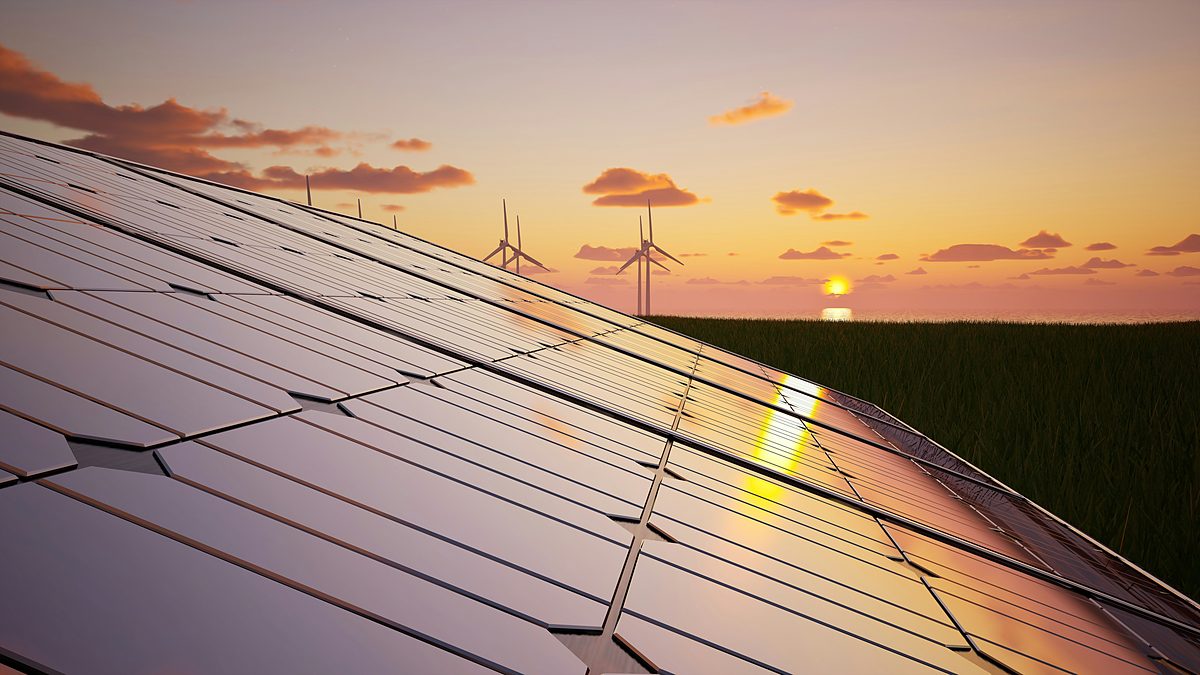 Solar panels and wind turbines at sunset