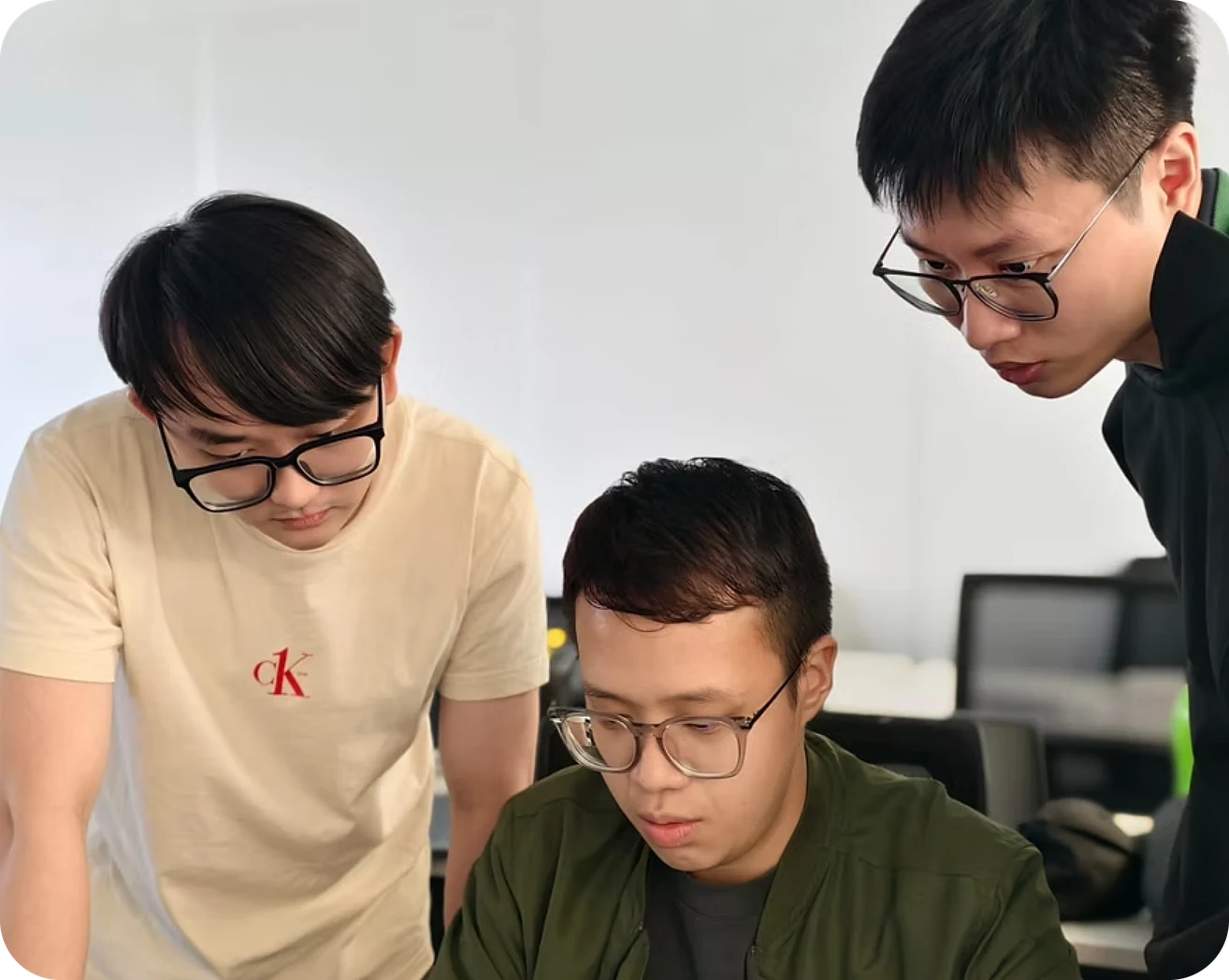 Three young engineers looking at a laptop together