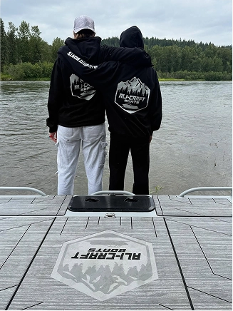 Two ali-craft boat owners wearing merch by the lake