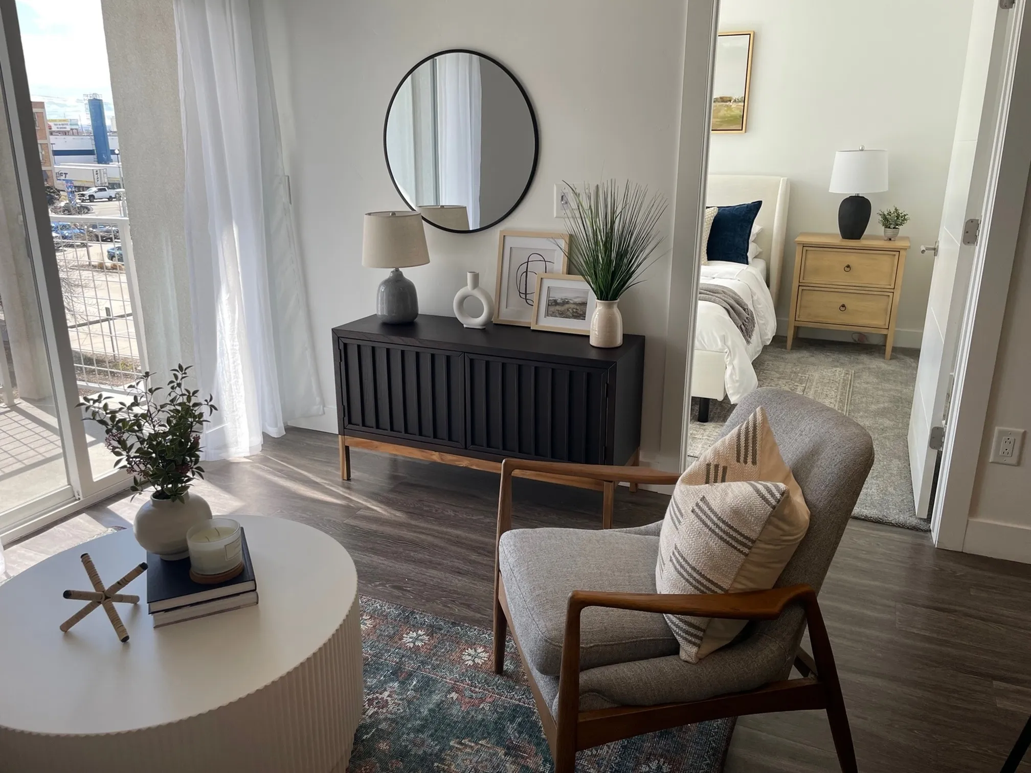 Living area with chair, coffee table and view into bedroom
