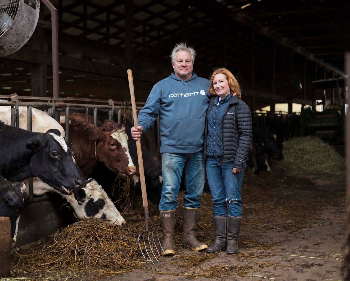 Dave and Casey Schoch standing together in the barn among their cows