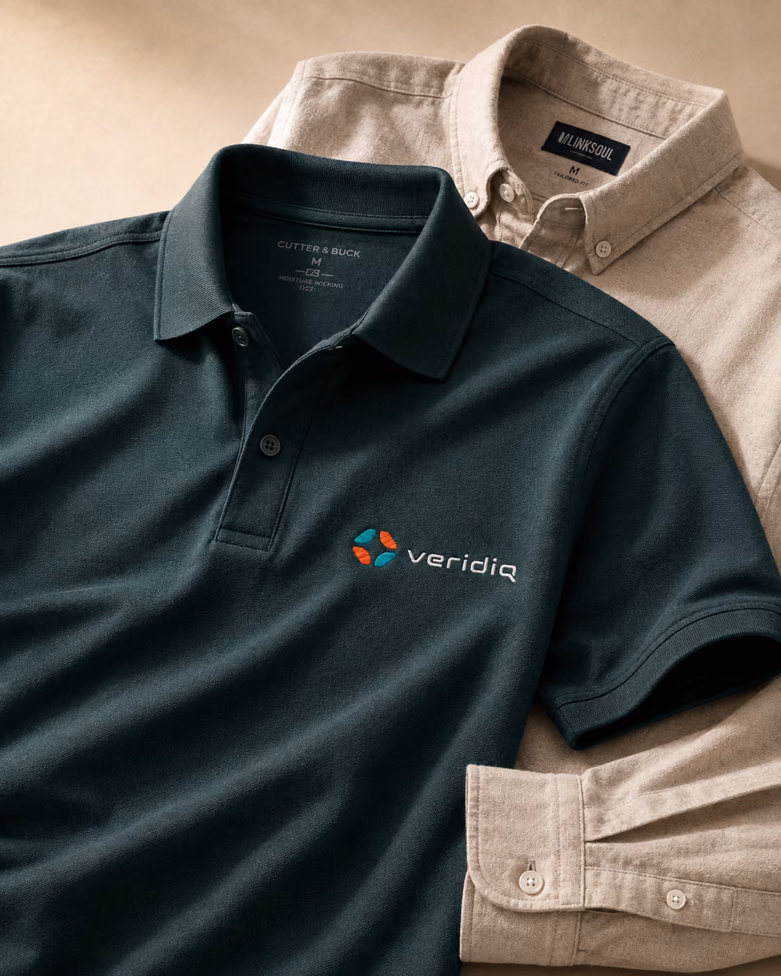 Green branded polo shirt next to a tan button-down