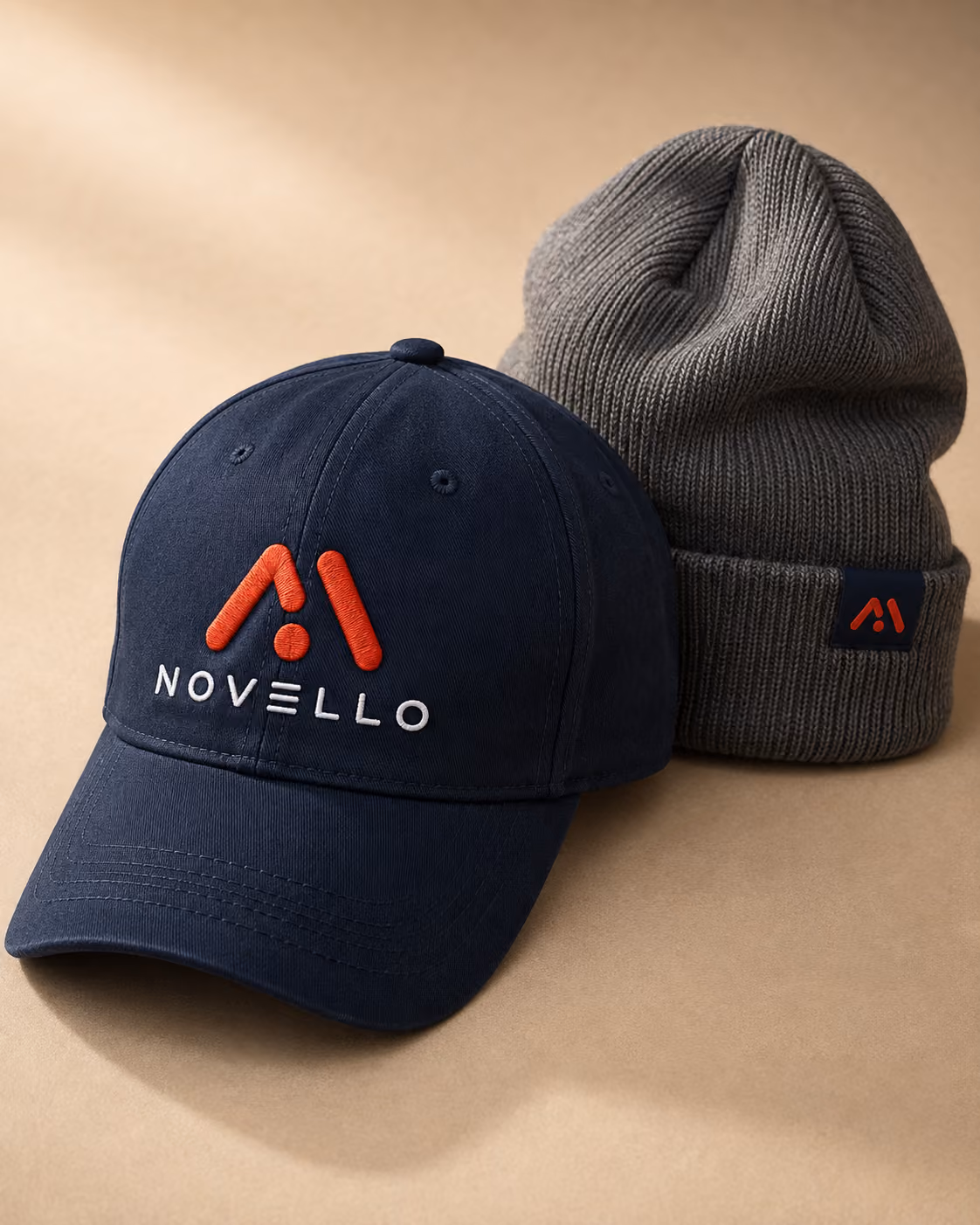 Navy branded baseball cap next to a grey beanie