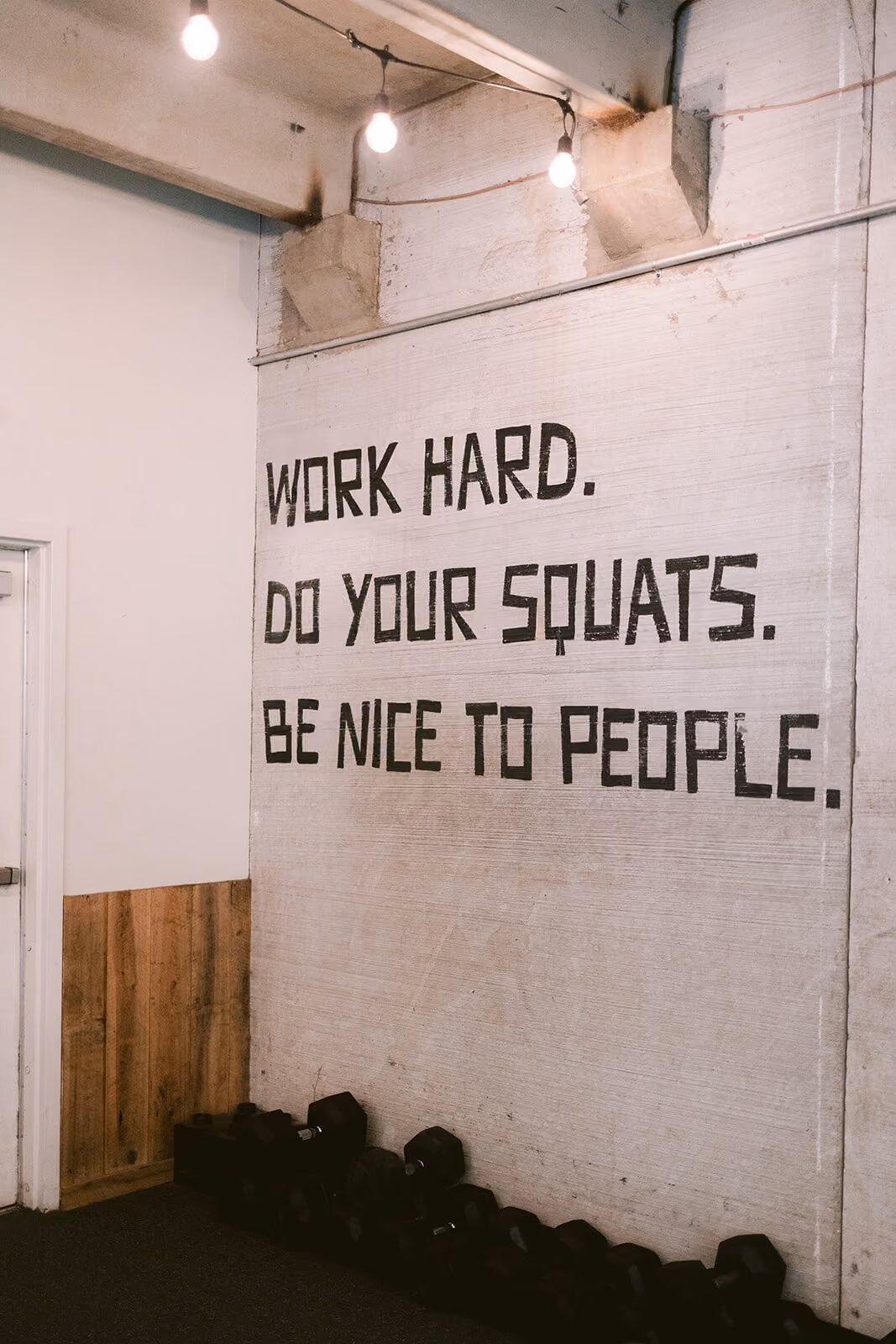 Signage that reads "Work hard. Do your squats. Be nice to people."