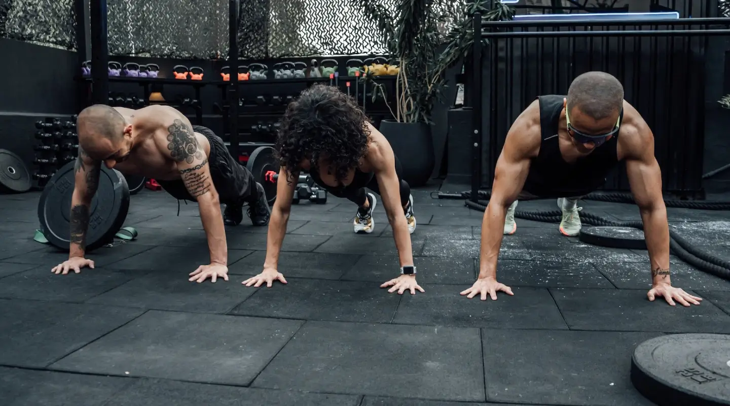 **Alt text:** Group of athletes performing push-ups during a CrossFit class at a fitness gym in Bakersfield, CA.