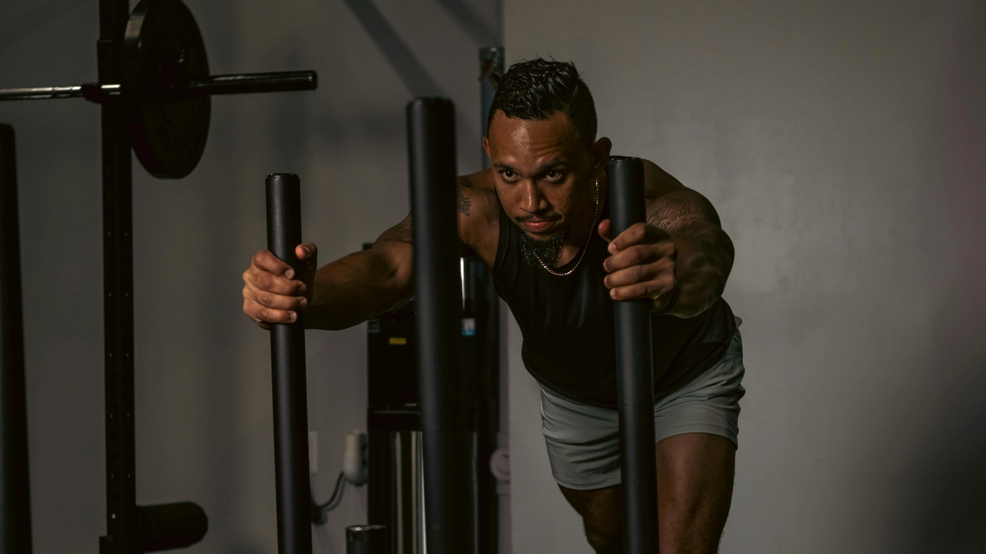 **Alt text:** Athlete pushing a weighted sled during a HYROX training class at a fitness gym in Bakersfield, CA.