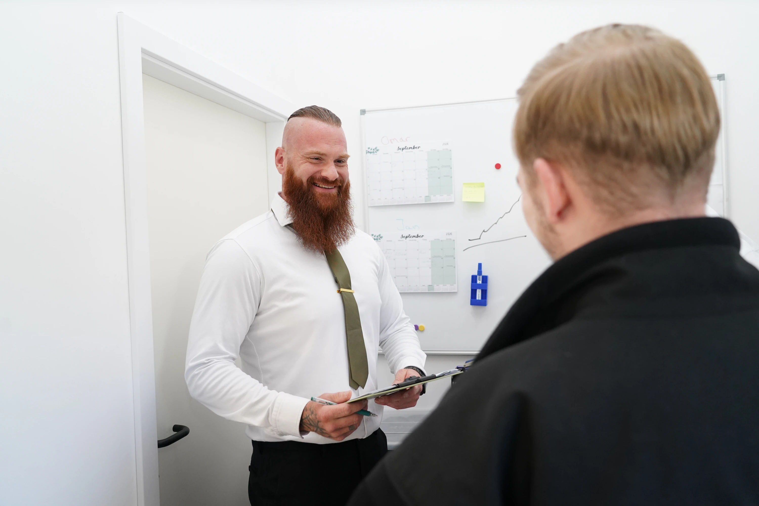 Betriebsleiter der Teuto-Sicherheit im Gespräch mit einem Auszubildenden