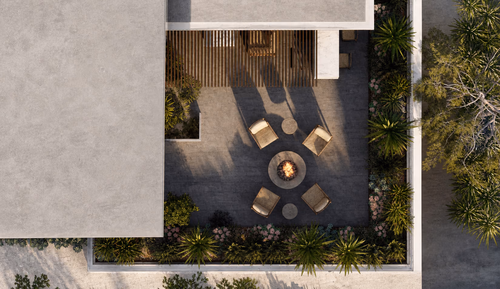 Top view of a patio with a fire pit surrounded by four chairs and plants bordering the area.